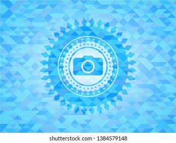 photo camera icon inside light blue emblem with triangle mosaic background