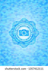 photo camera icon inside realistic light blue emblem. Mosaic background