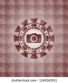 photo camera icon inside red seamless badge with geometric pattern background.