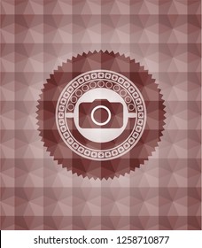photo camera icon inside red emblem or badge with abstract geometric polygonal pattern background. Seamless.