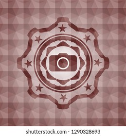 photo camera icon inside red seamless badge with geometric pattern background.