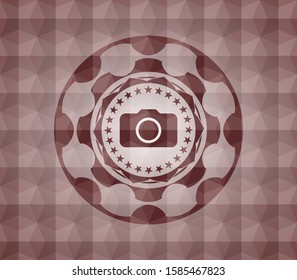 photo camera icon inside red seamless emblem or badge with geometric pattern background.