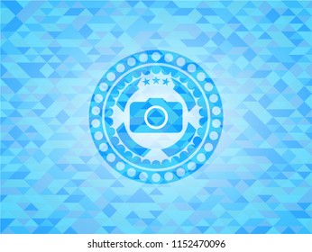 photo camera icon inside sky blue emblem with triangle mosaic background
