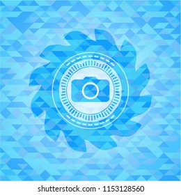 photo camera icon inside sky blue emblem with triangle mosaic background