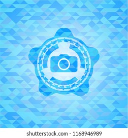 photo camera icon inside sky blue emblem. Mosaic background