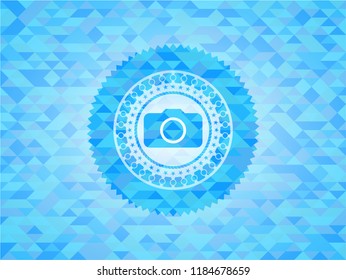 photo camera icon inside sky blue emblem with triangle mosaic background