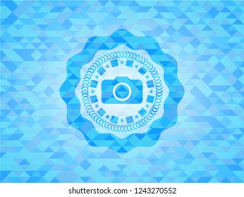photo camera icon inside sky blue emblem with triangle mosaic background