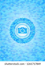 photo camera icon inside sky blue emblem with mosaic ecological style background
