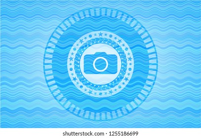 photo camera icon inside water wave style badge.