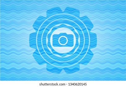 photo camera icon inside water wave representation style emblem.