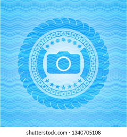 photo camera icon inside water wave representation badge.