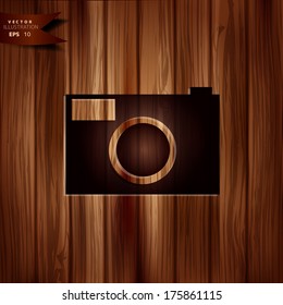 Photo camera icon. Photography. Wooden texture.