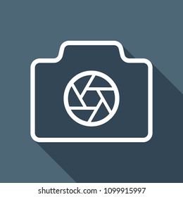 Photo camera with shutter, linear symbol with thin outline, simple icon. White flat icon with long shadow on background