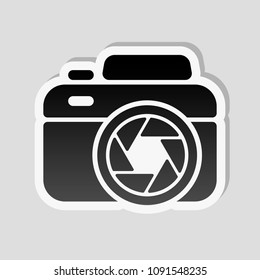 Photo camera with shutter, simple icon. Sticker style with white border and simple shadow on gray background