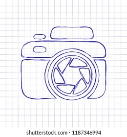 Photo camera with shutter, simple icon. Hand drawn picture on paper sheet. Blue ink, outline sketch style. Doodle on checkered background