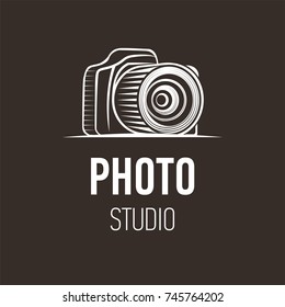 Photo camera silhouette symbol on dark background. Logo design for photo studio