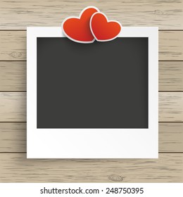 Photo frame with 2 hearts on the wooden background. Eps 10 vector file.