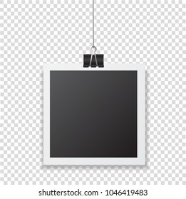 Photo frame with shadow hanging with paper clip. Black square snapshot and metal blinder isolated on transparent background. Vector silver paperclip on picture for your design