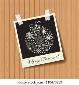 Photo frame with snowflakes ball on wooden background. Christmas concept