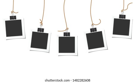 Photo square frames hanging on a black paper clip and beautiful shadow on white background.