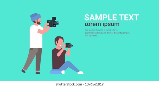 photographer and cameraman using cameras shooting video taking pictures working together teamwork during studio session horizontal full length flat copy space