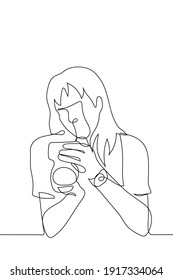 photographer checks the captured photo in the camera. one line drawing a professional female photographer evaluates the pictures taken