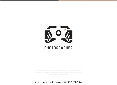Photographer Logo Design. Vector Logo Template. A smart logomark of two hands holding a DSLR camera in a negative effect. A symbol representing quality portrait, nature, wedding and other photography 