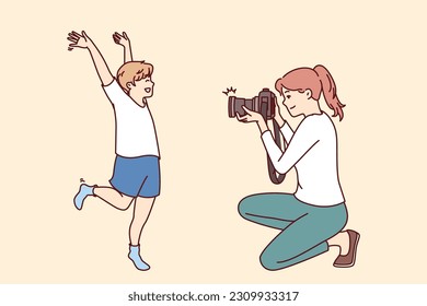 Mutter und kleiner Junge des Fotografen machen professionelles Fotoshooting, um glückliche Momente aus der Kindheit zu erfassen. Son glücklich posiert für weibliche Kinderfotografen, die Familienalbum vorbereiten