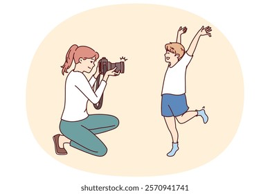 Photographer mother and little boy make professional photoshoot to capture happy moments from childhood. Son happily poses for female child photographer preparing family photo album