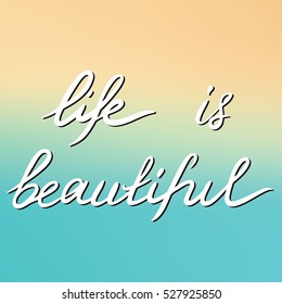 Phrase Life is beautiful. Handwritten phrase on the blurred  background.