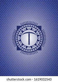 pickaxe icon inside badge with denim texture