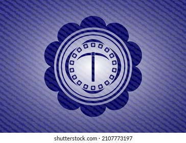pickaxe icon inside badge with jean texture. 