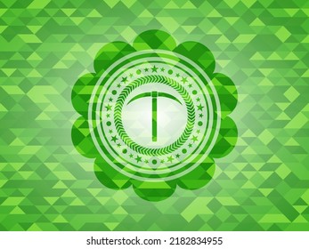 pickaxe icon inside green emblem with mosaic background. 