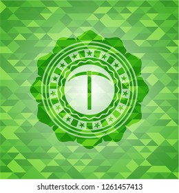 pickaxe icon inside realistic green emblem. Mosaic background