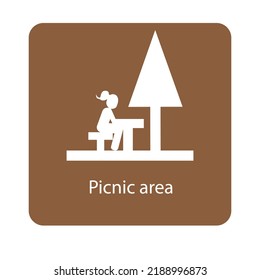 Picnic area sign with a girl sitting on a picnic table under a tree