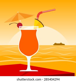 picture of a cocktail standing on table in front of sunset on the beach