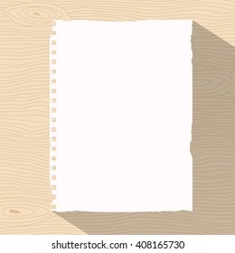 Piece of ripped white notebook paper is stuck on light brown wooden wall or desk