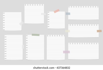 Pieces of cut out white notebook paper are stuck on gray striped background