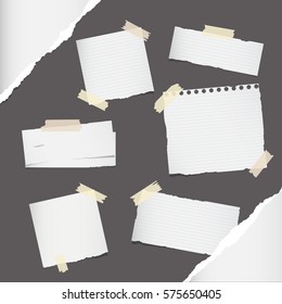 Pieces of different size colorful note, notebook, copybook paper sheets stuck with sticky tape on gray background