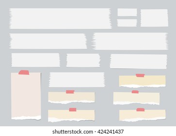 Pieces of ripped brown blank note paper, white sticky, adhesive tapes are stuck on gray wall
