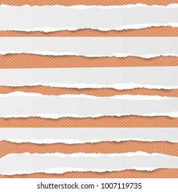 Pieces of ripped white blank note, notebook paper strips stuck on orange squared background