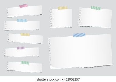 Pieces of ripped white blank notebook paper are stuck with striped sticky tape.