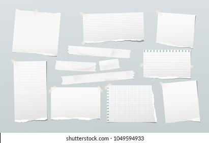 Pieces of torn white note, notebook paper stuck with sticky tape on gray background