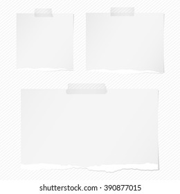 Pieces of torn white squared notebook paper with sticky tape on light background