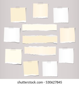 Pieces of white and beige torn note, notebook paper sheets stuck on grey background