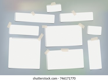 Pieces of white lined copybook, notebook sheets for note stuck with sticky tape gray background