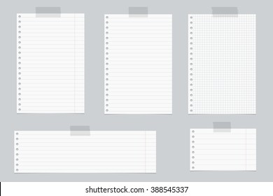 Pieces of white lined and squared notebook paper with sticky tape on gray background