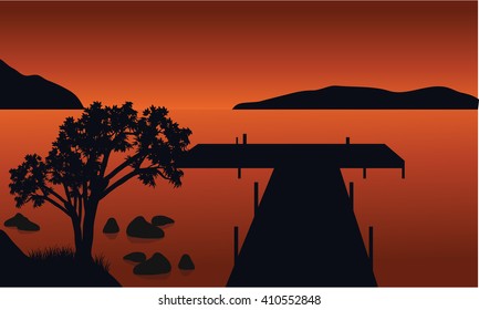 Pier and tree silhouette with orange backgrounds