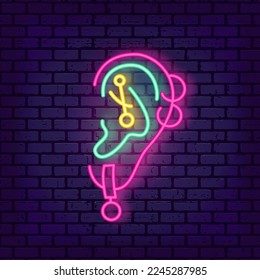 Piercing studio neon light sign. Pierced ear. Vector illustration on brick wall background. Line icon element. Small business identity. Cool jewelry shop emblem.