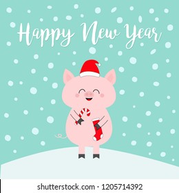 Pig holding candy cane, sock. Red Santa Claus hat. Happy New Year 2019. Cute funny cartoon character on snowdrift. Merry Christmas. Flat design. Blue winter background with snow flake. Vector